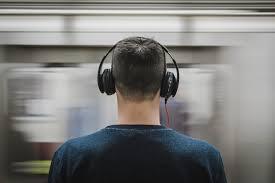 A Man Wearing Headphones on the Subway